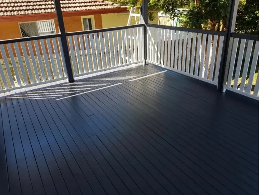 Deck after: freshly painted charcoal boards with white balustrade