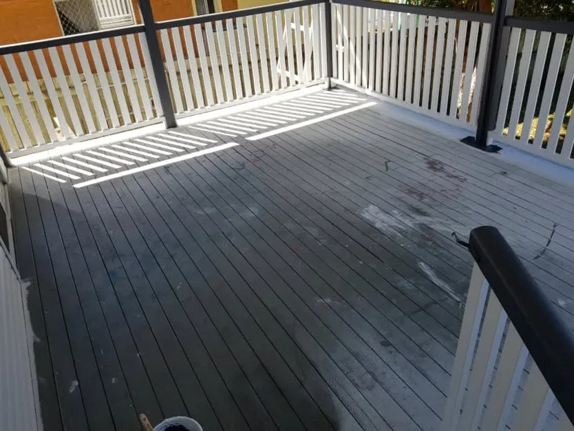Deck before: worn grey boards with paint marks