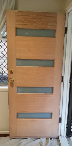 Front door before: bare pale timber
